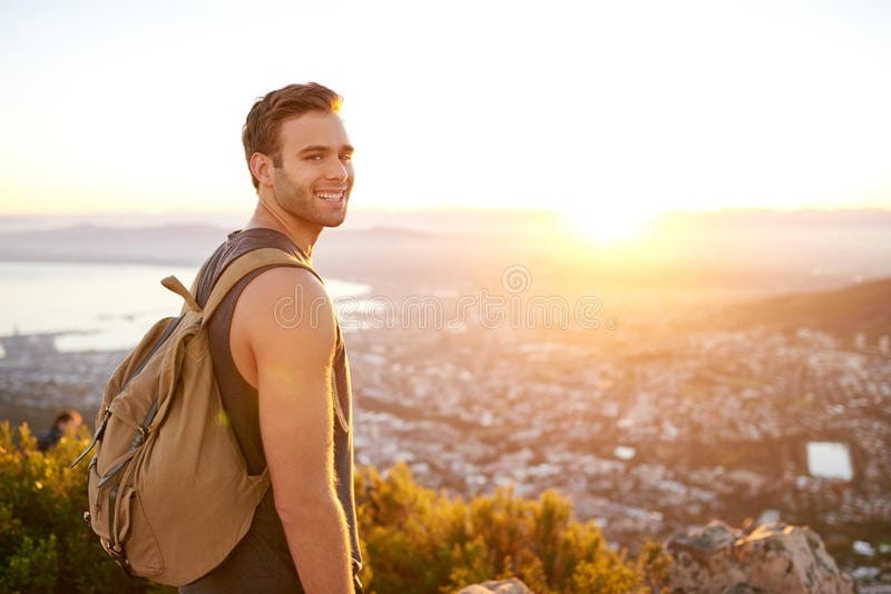 young-man-nature-trail-view-city-smiling-standing-early-morning-55415162.jpg